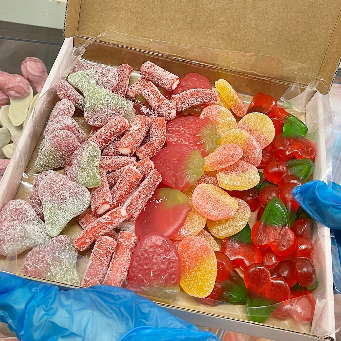 Image of a pick and mix box made up filled with a variety of different red sweets- Rupert's Candy