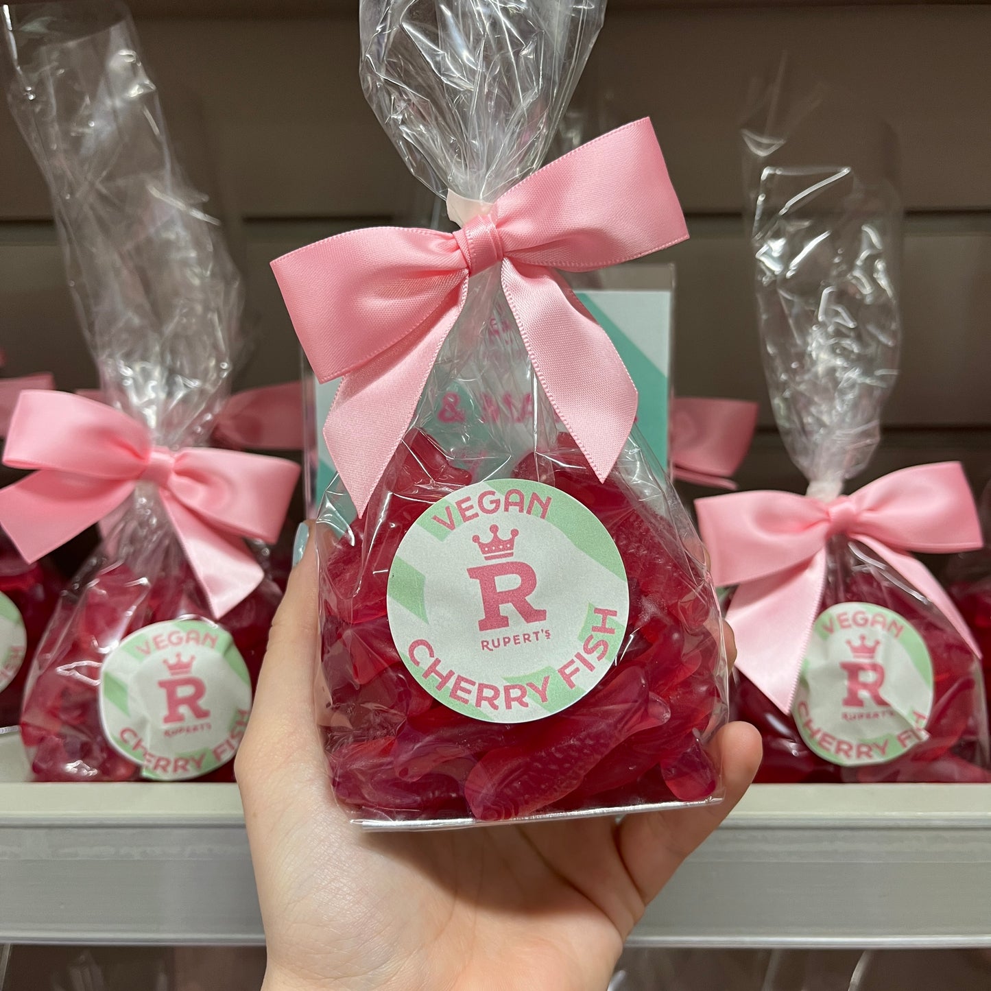 Small gift bag of vegan cherry fish being held up from shelf- Rupert's Candy