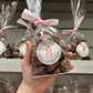 Hand holding up a bag of our chocolate cinder toffee- Rupert's Candy