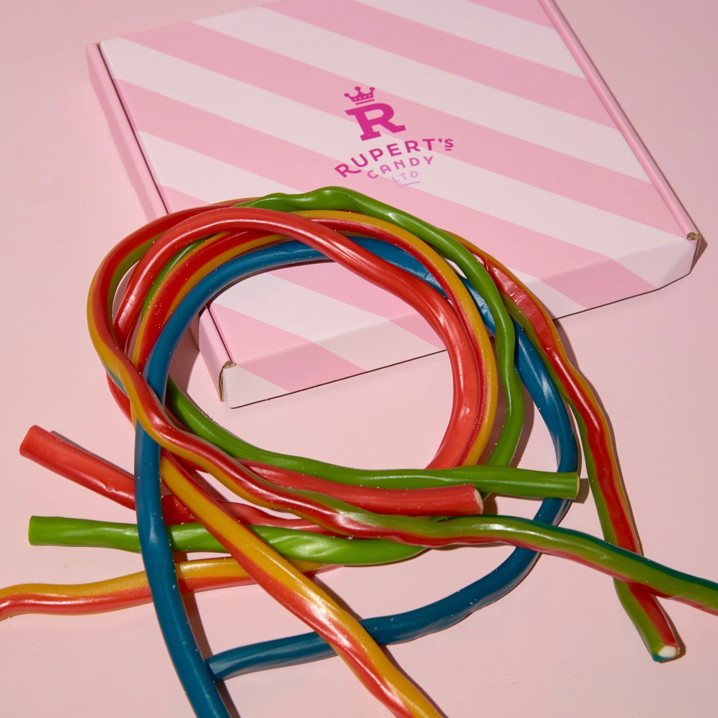 Close up image of our different flavours of cables placed onto of our pink Rupert's box- Rupert's Candy