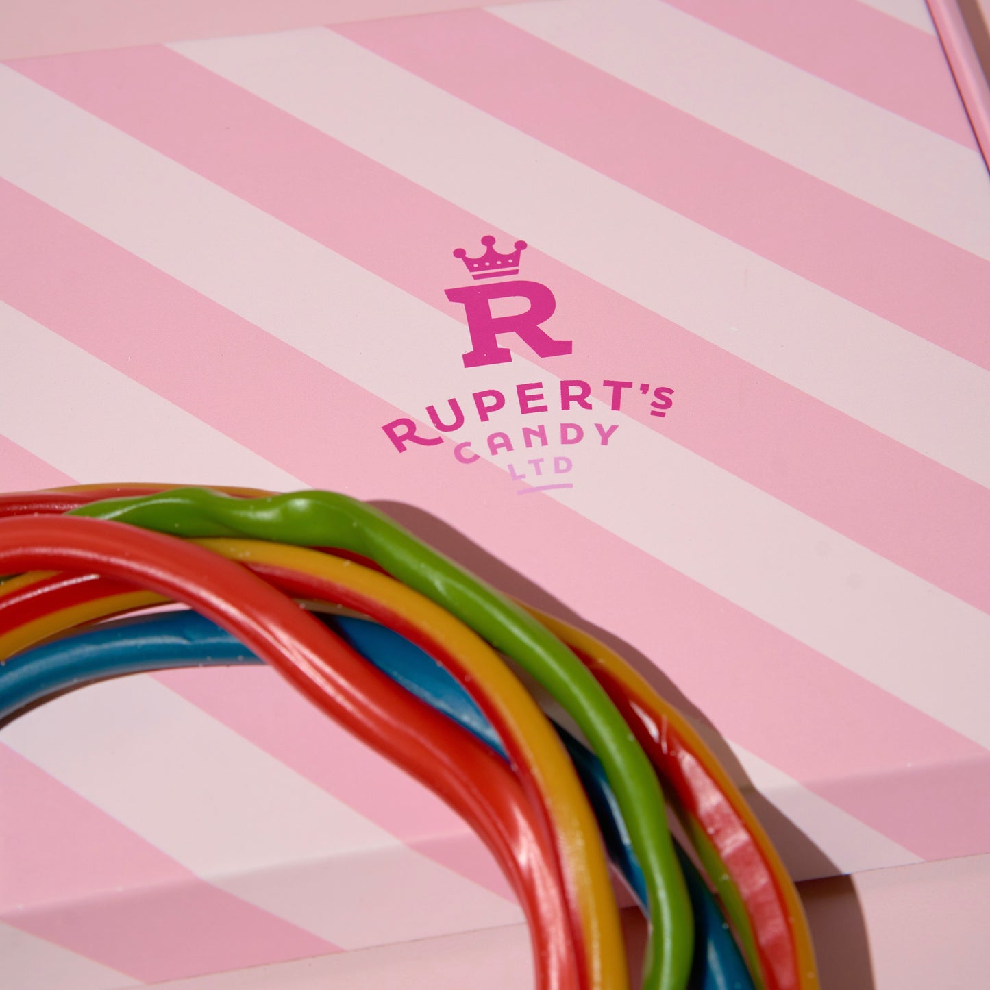 Close up image of our pink Ruperts box with cables placed on top of it- Rupert's Candy