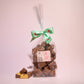 Large gift bag of chocolate cinder toffee with a piece broken up placed next to it- Rupert's Candy