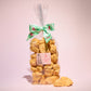 Large gift bag of our naked honeycomb cinder toffee with pieces of honeycomb placed in front of the bag- Rupert's Candy