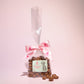 Small gift bag of chocolate enrolled raisins with some chocolate raisins placed in front- Rupert's Candy