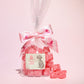 Small gift bag of cola cubes with some cola cubes placed in front of it- Rupert's Candy