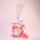 Small gift bag of cola cubes with some cola cubes placed in front of it- Rupert's Candy