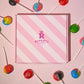 Close up image of our Rupert's candy pink box with the different lollies laid around it- Rupert's Candy