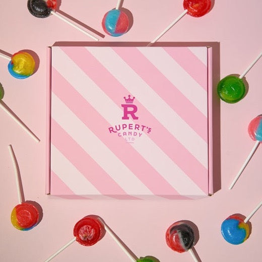 Close up image of our Rupert's candy pink box with the different lollies laid around it- Rupert's Candy