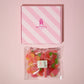 Birds Eye view image of our pink Rupert's Candy box with a bag of our red mix laid underneath it- Rupert's Candy