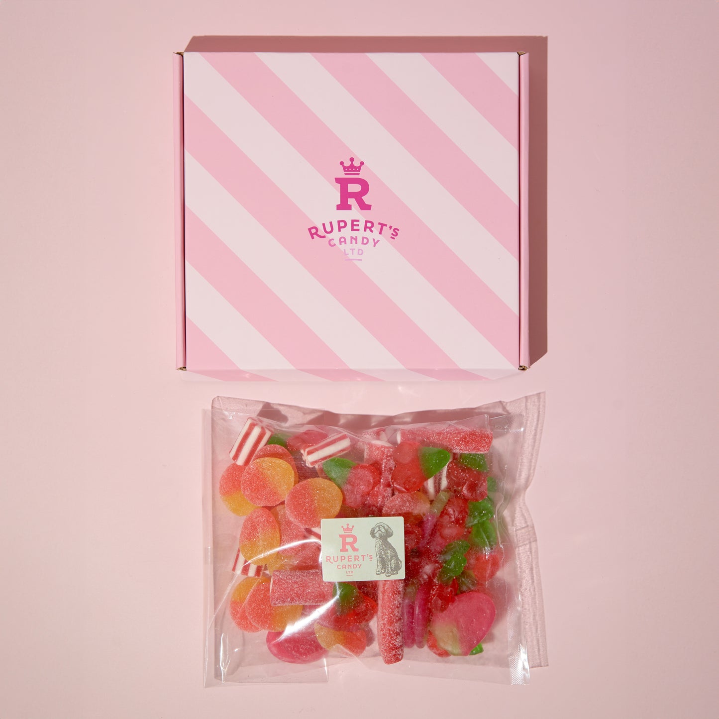 Birds Eye view image of our pink Rupert's Candy box with a bag of our red mix laid underneath it- Rupert's Candy