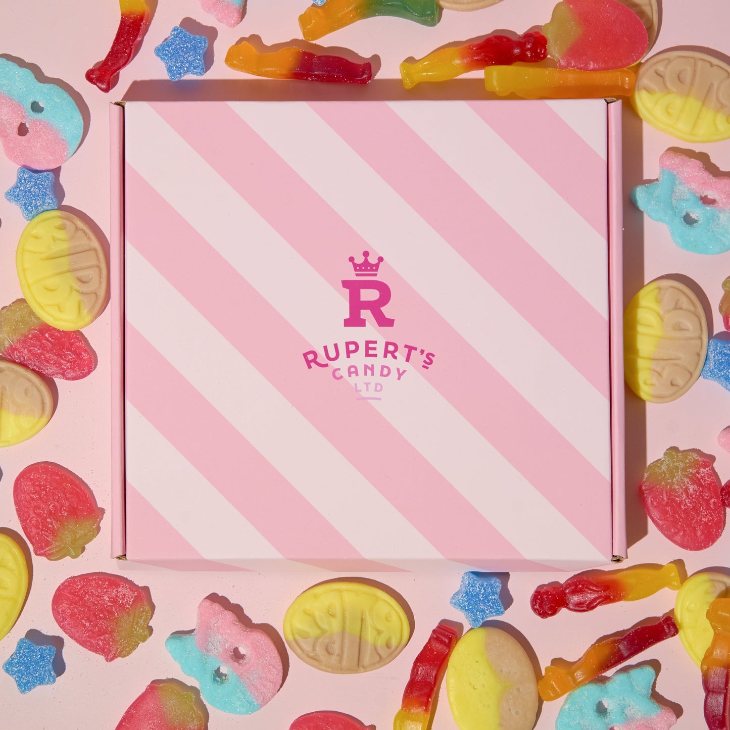 Image of our pink Rupert's Candy box with a our vegan sweets scattered around it- Rupert's Candy