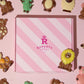 Close up Birds Eye view of our pink Rupert's candy box with the different belgian chocolate animals around it and on top- Rupert's Candy